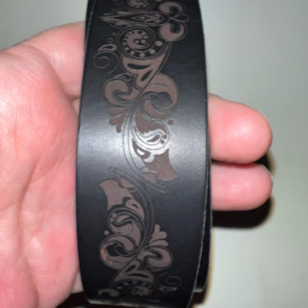 Timberland black leather belt laser etched floral design. Silver art deco buckle